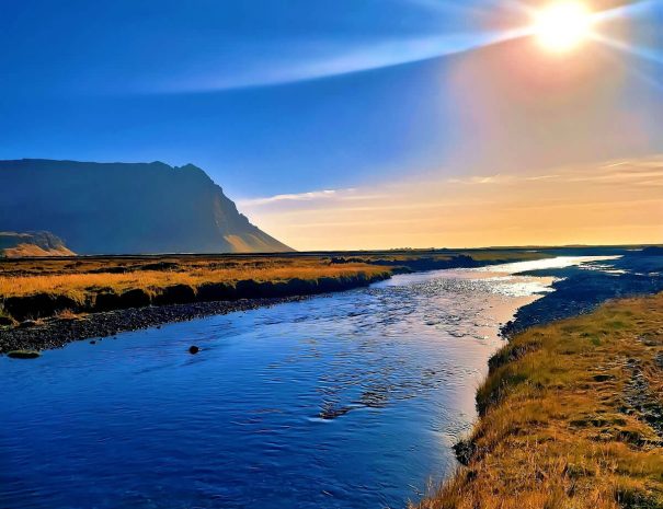 green-farm-stay-cabin-stream-sunset