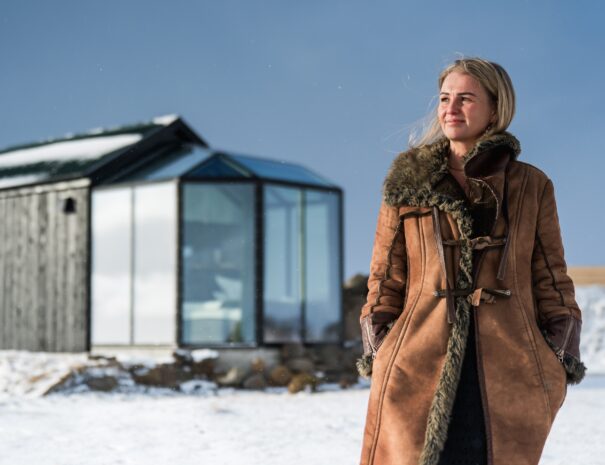 Glass igloo in winter Iceland with Person Standing in front