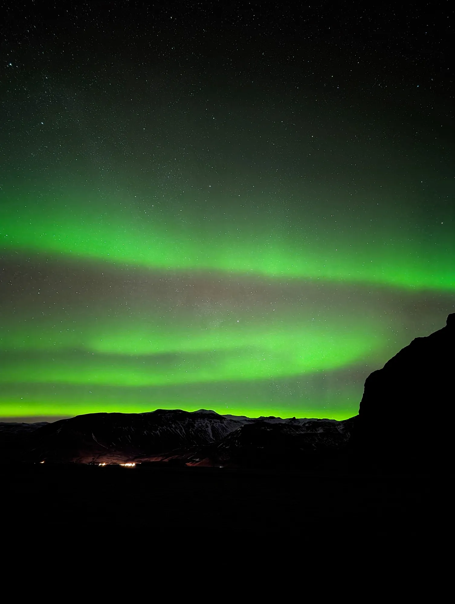 Green aurora arcs over Holtsnúpur and the Eyjafjöll mountains, seen from Ormskot