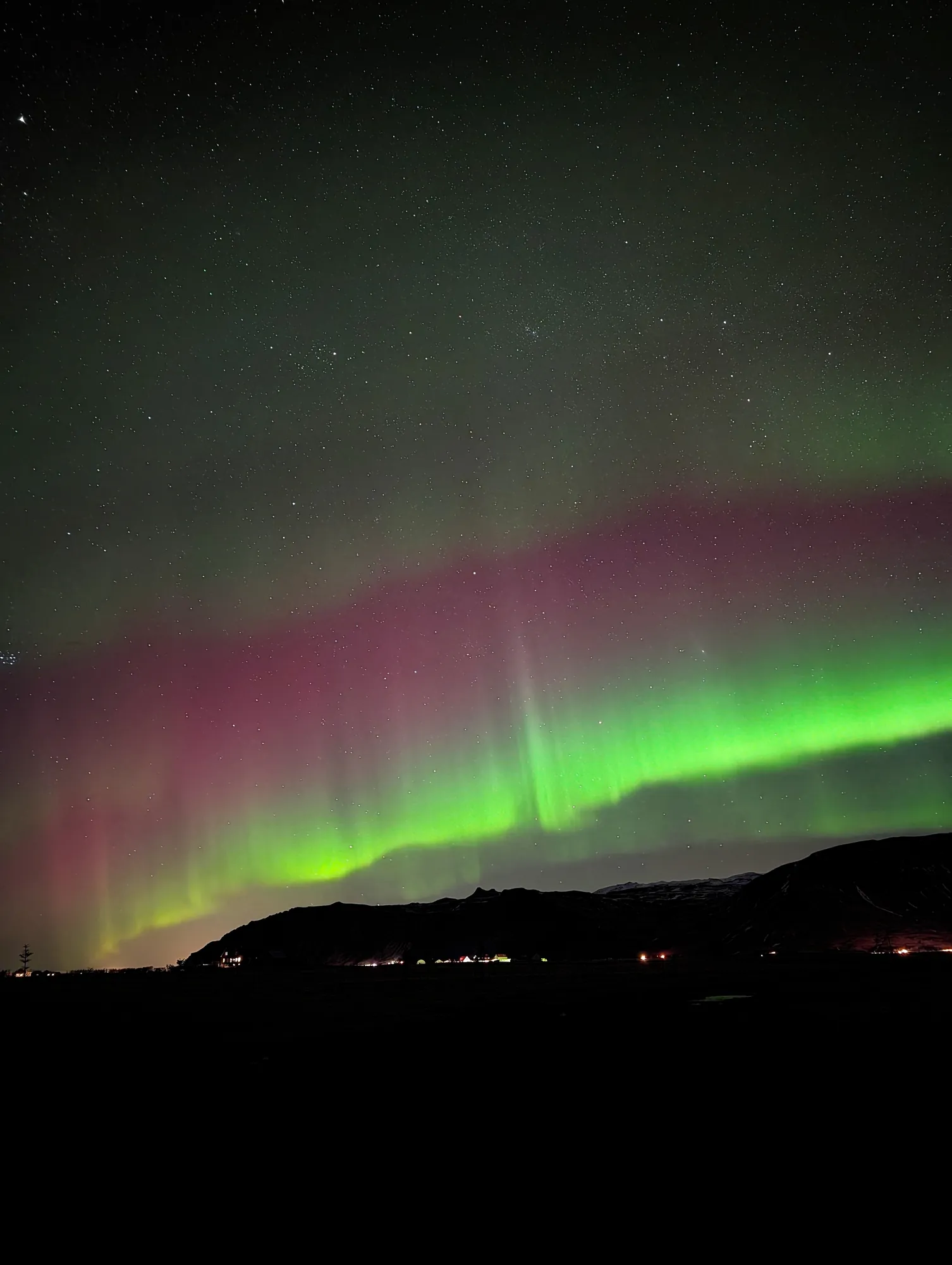 Red and green aurora band above Stóri-Dímon in the Markarfljót plain, South Iceland