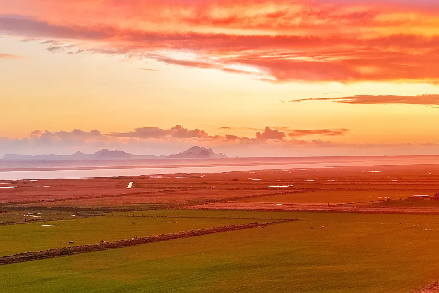Summer sunset over the fields at Ormskot farm with the Westman Islands on the horizon, South Iceland