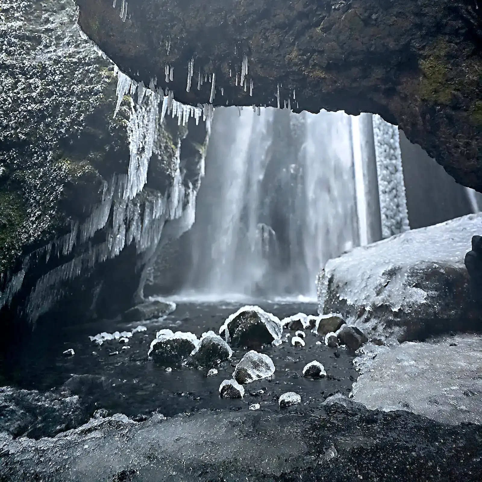 Inside Gljufrabui cave frozen waterfall with icicles South Iceland