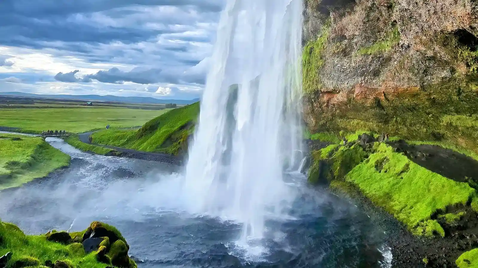Seljalandsfoss waterfall side view with lush green Icelandic landscape