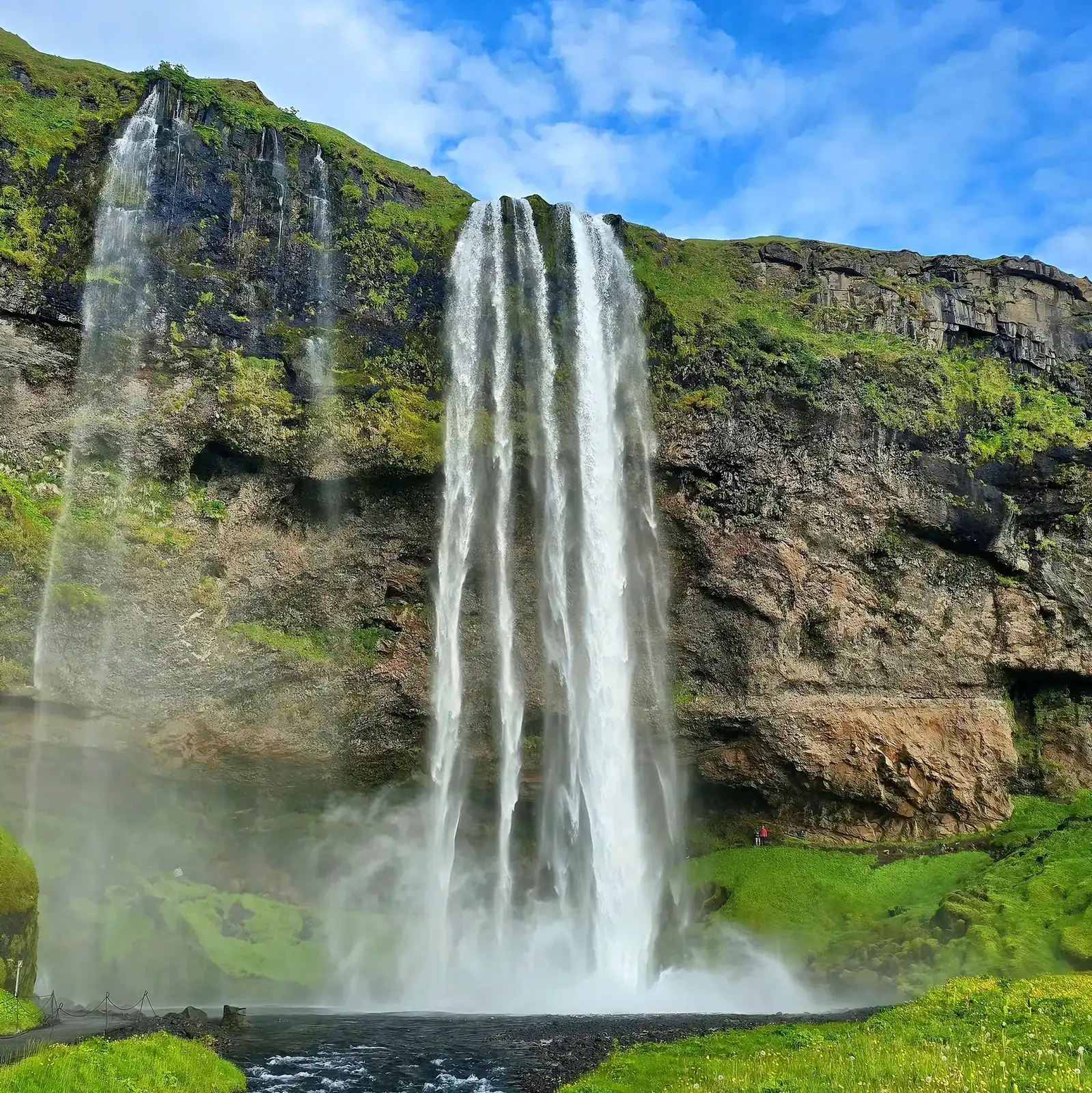 Seljalandsfoss waterfall in summer with green moss South Iceland