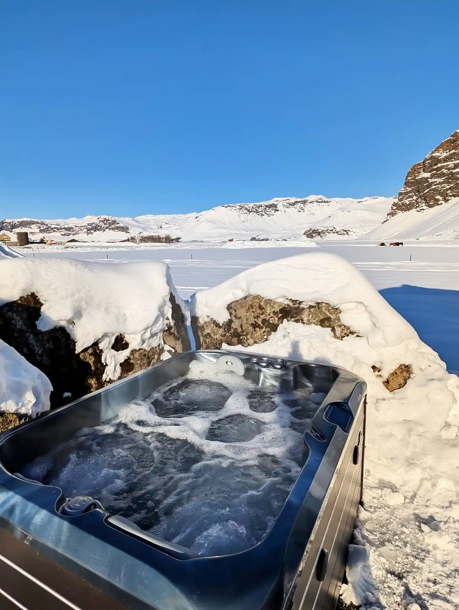 Private hot tub jacuzzi in snow at Sky Retreat Iceland mountain views